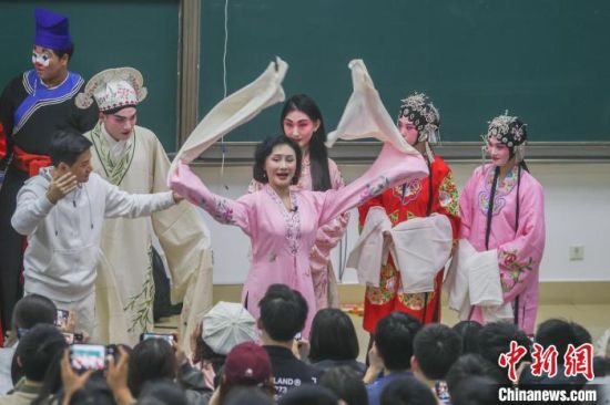 图为身穿戏服的陈俐(粉红色服饰)给学生们演示舞袖。 记者 刘力鑫 摄
